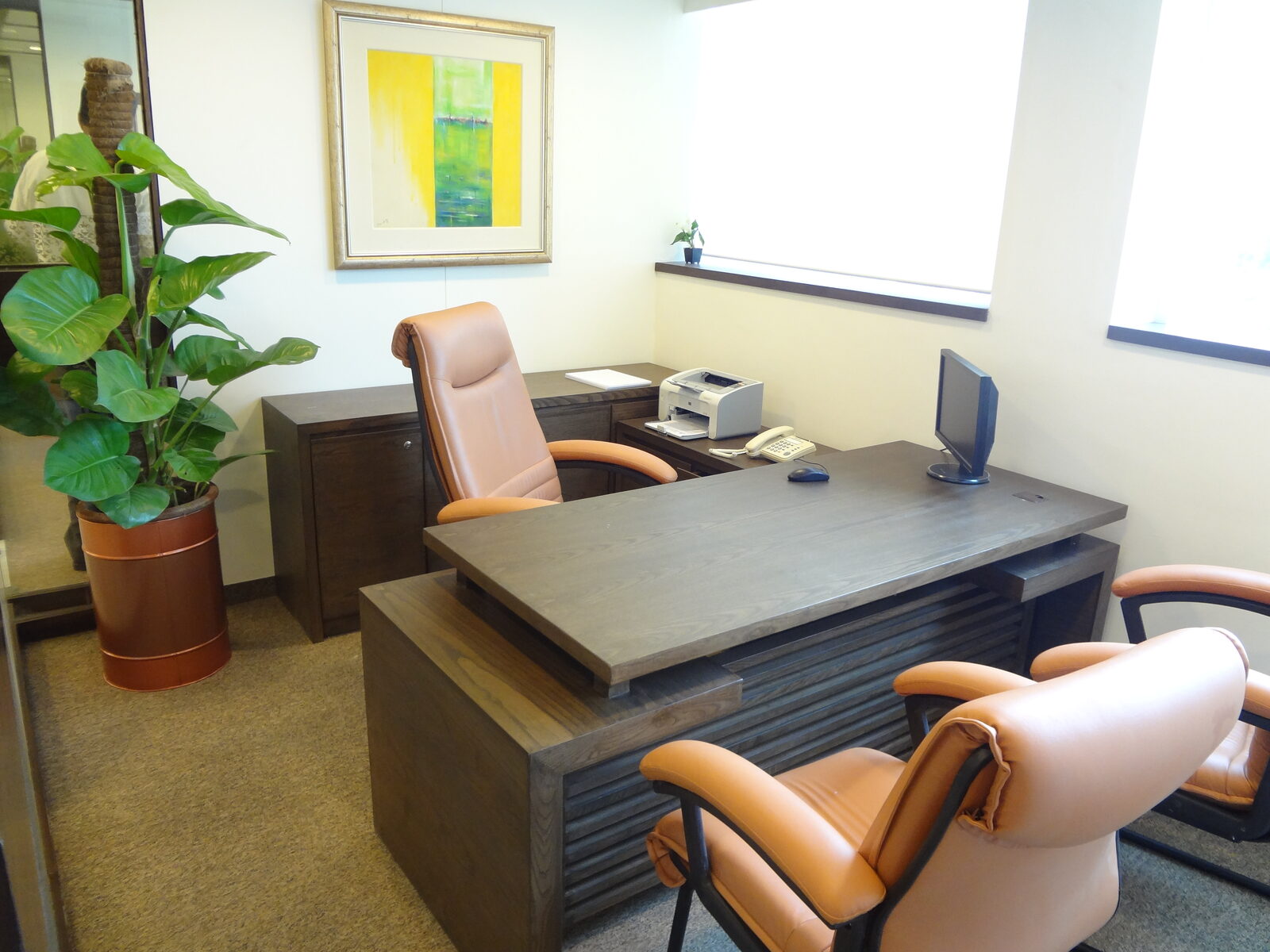 Executive office with grey-stained timber desk, return unit, credenza and tan leather chairs