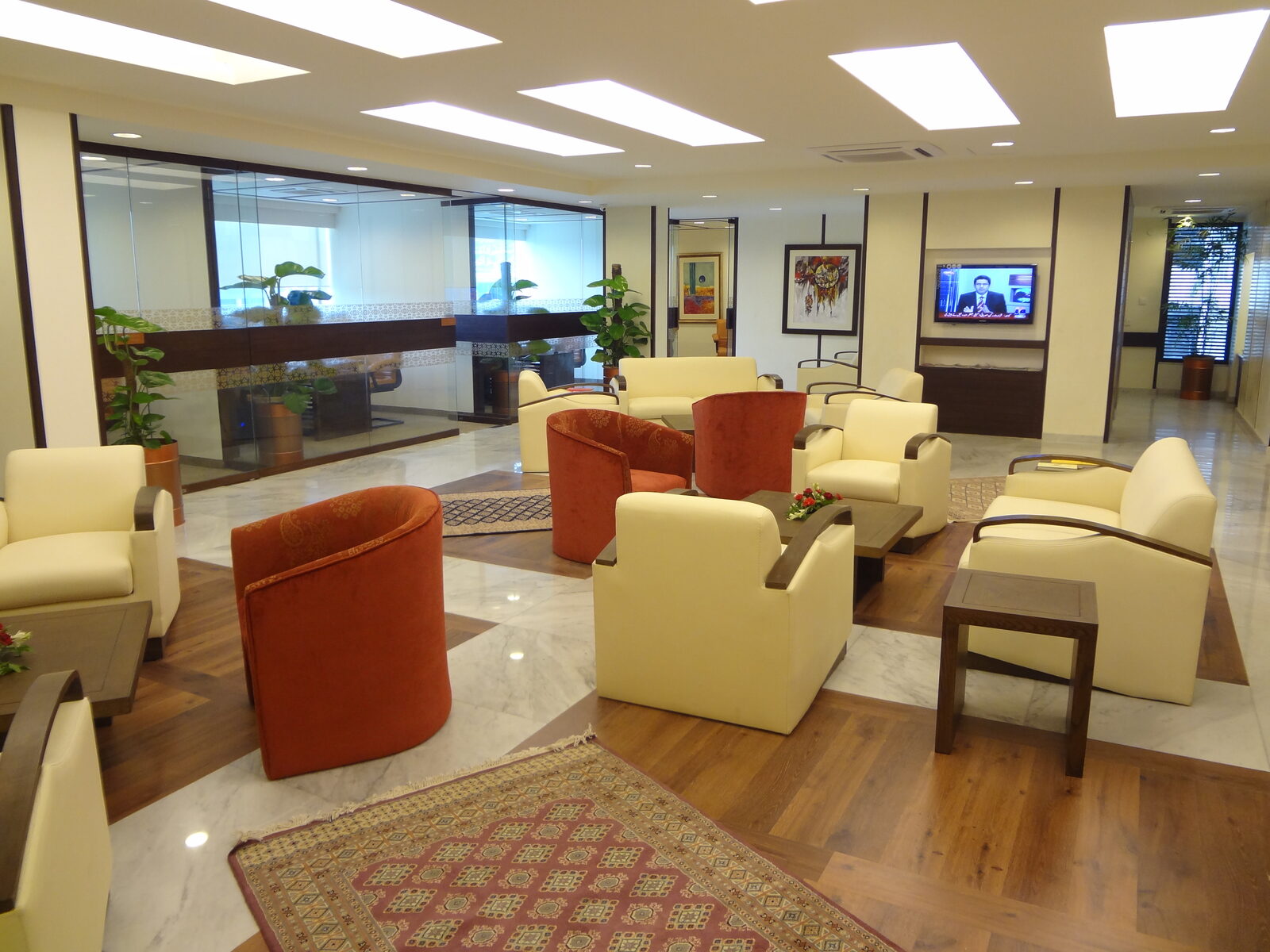 Priority banking customer lounge with leather armchairs, timber tables and glazed partition offices