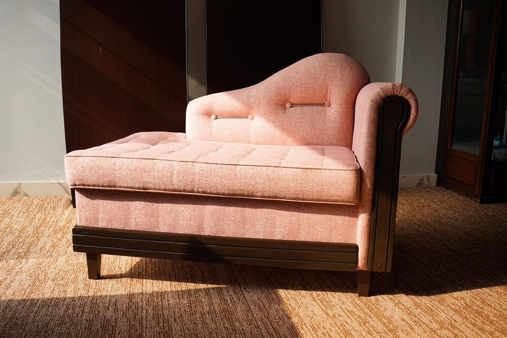 Blush upholstered chaise with studded timber frame