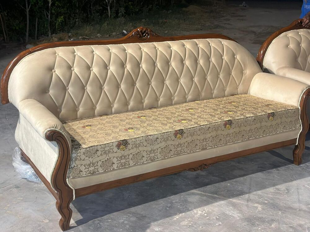Carved timber sofa with buttoned cream upholstery