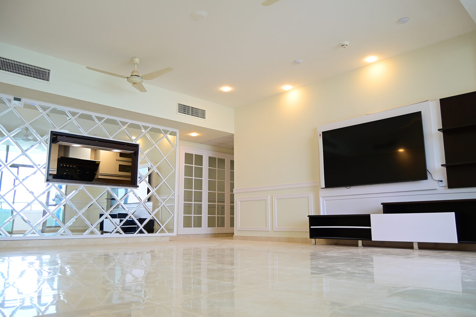 Living room from floor level showing television wall, panelling and floating shelves